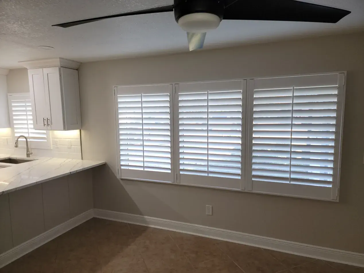 Full height shutters in kitchen with marble countertops