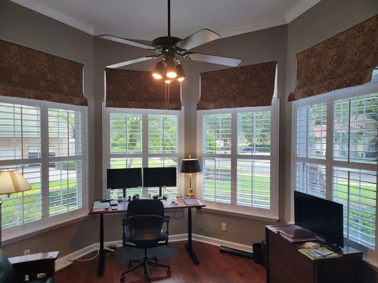 Full height shutters in home office with wraparound windows