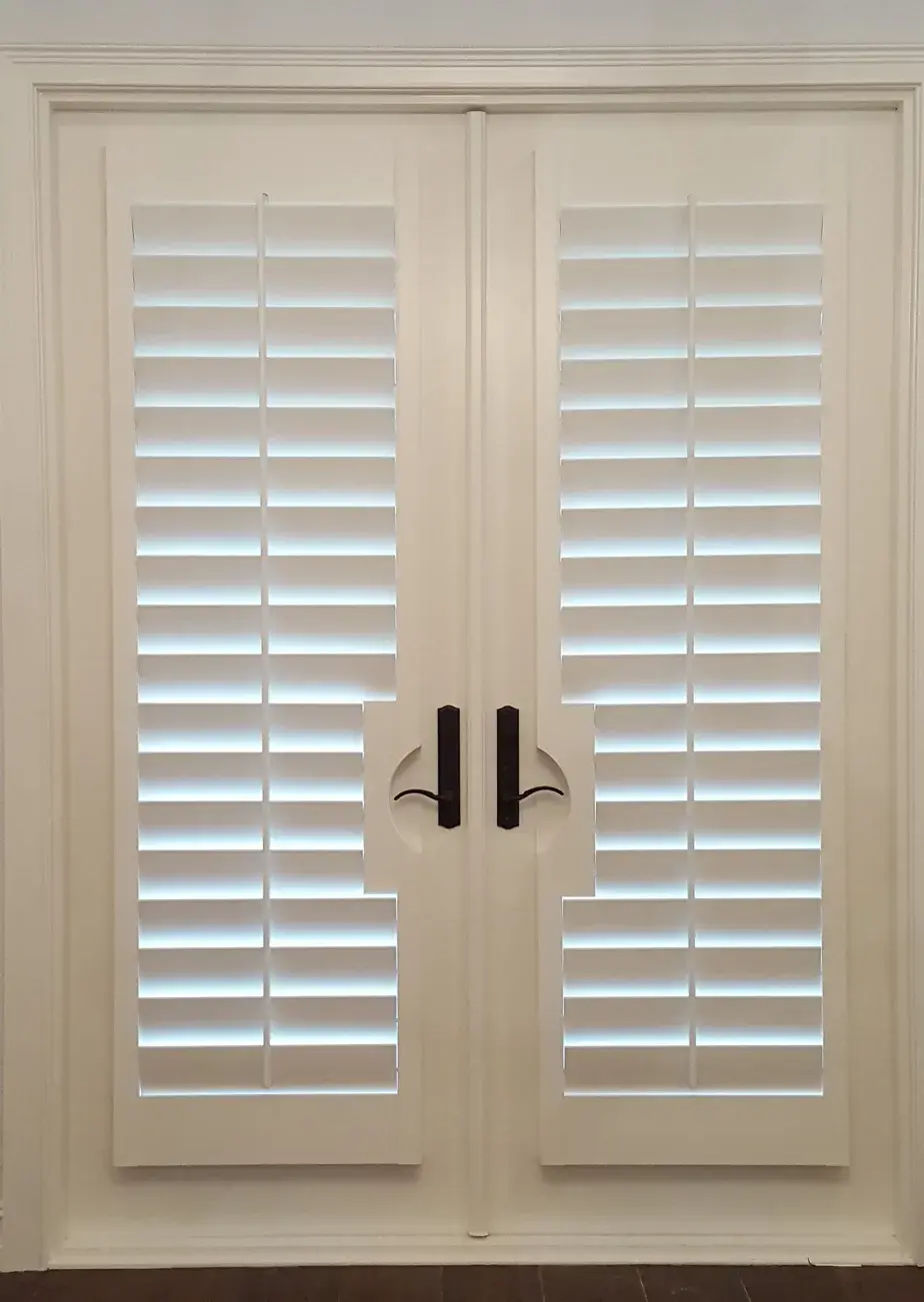 French doors with plantation shutters and dark hardware