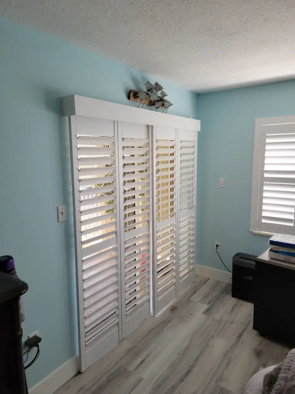 Bypass sliding shutters in office with blue walls