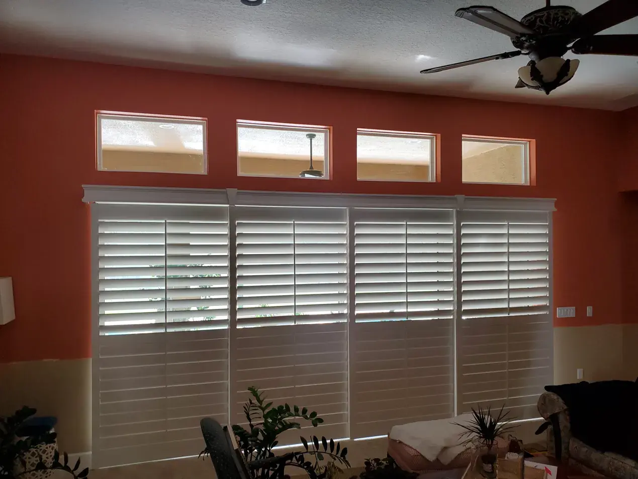 Full height shutters in living room with high windows